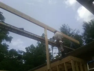 Carpenter setting a ridge beam over a new addition frame — Ice Dam Removal by Roofing Brothers in Millbrae