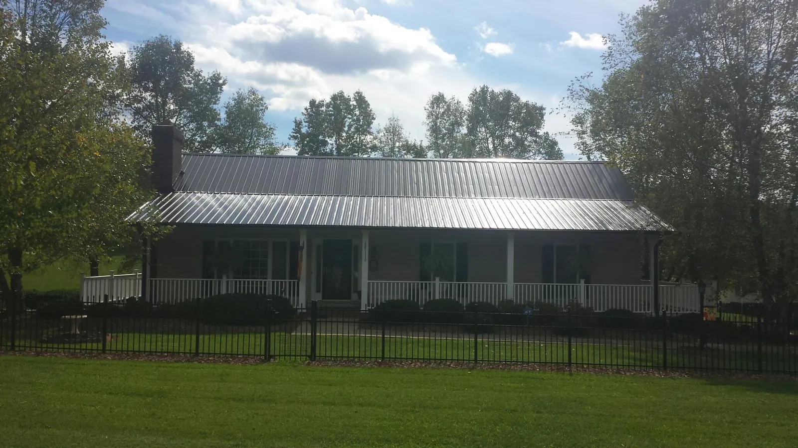 Gray metal roof on a brick ranch with a full width front porch — Gutter Guard Installation work by our crew in Millbrae